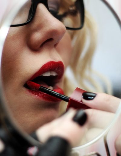 Alexandra Wildfire applying her red lipstick