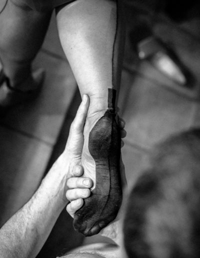 Person lifting leg while wearing a stocking, black and white photography, intimate close-up.